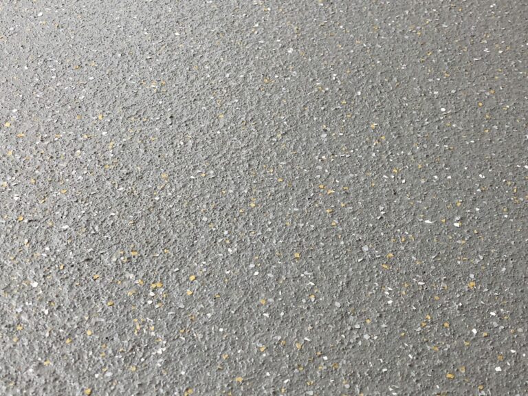 Draufsicht auf die Beschichtung mit Quarzsand und farbigen Chips
