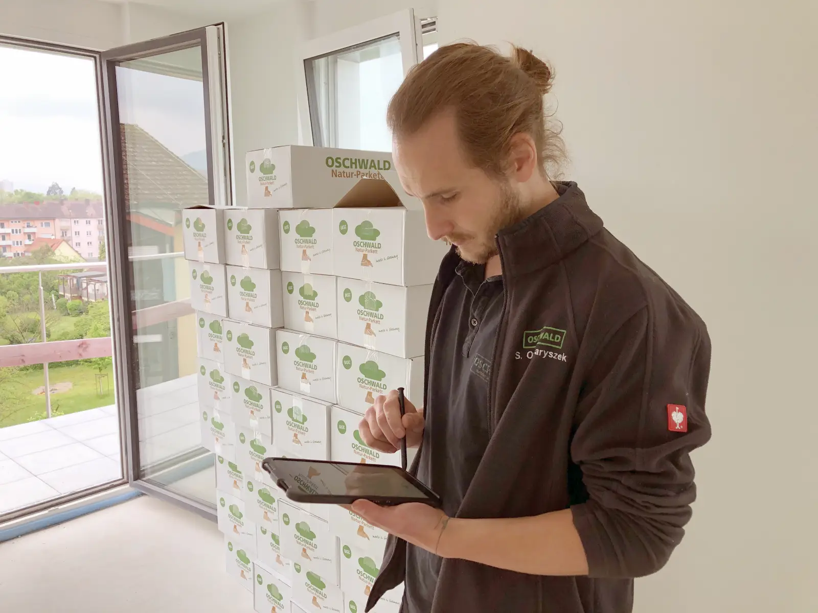OSCHWALD-Bauleiter mit Tablet auf der Baustelle
